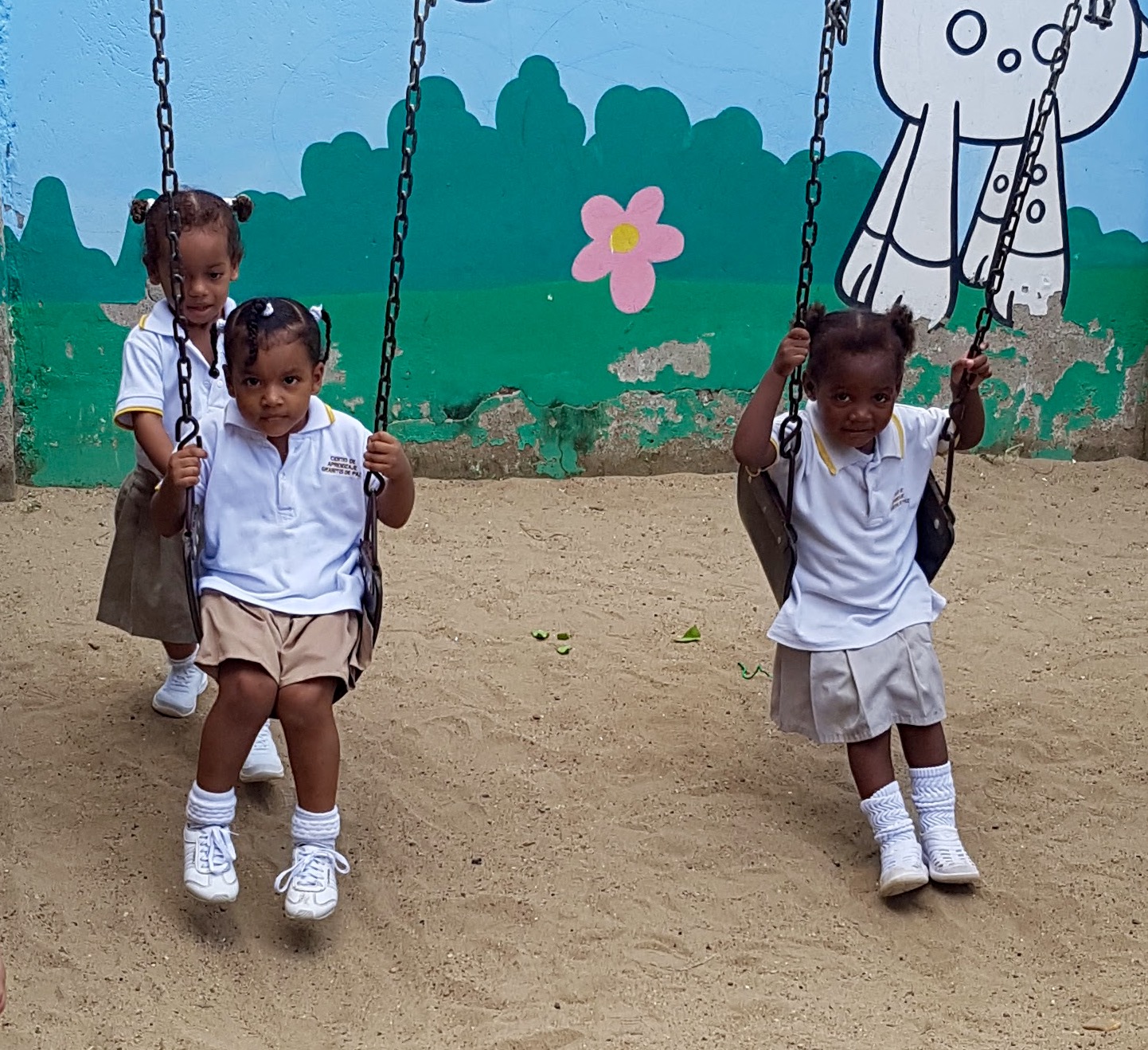 Children on swings on volunteer duty in Cartagena