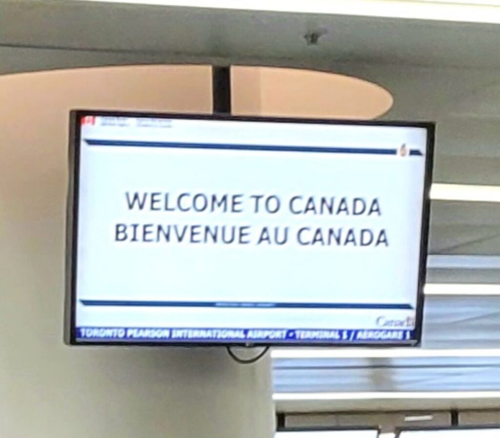 return to Toronto after living on a boat Welcome to Canada sign