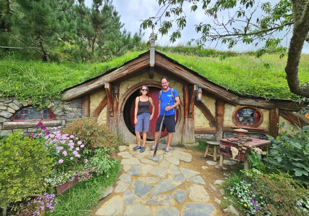 Posing in front of a hobbit house in Hobbiton