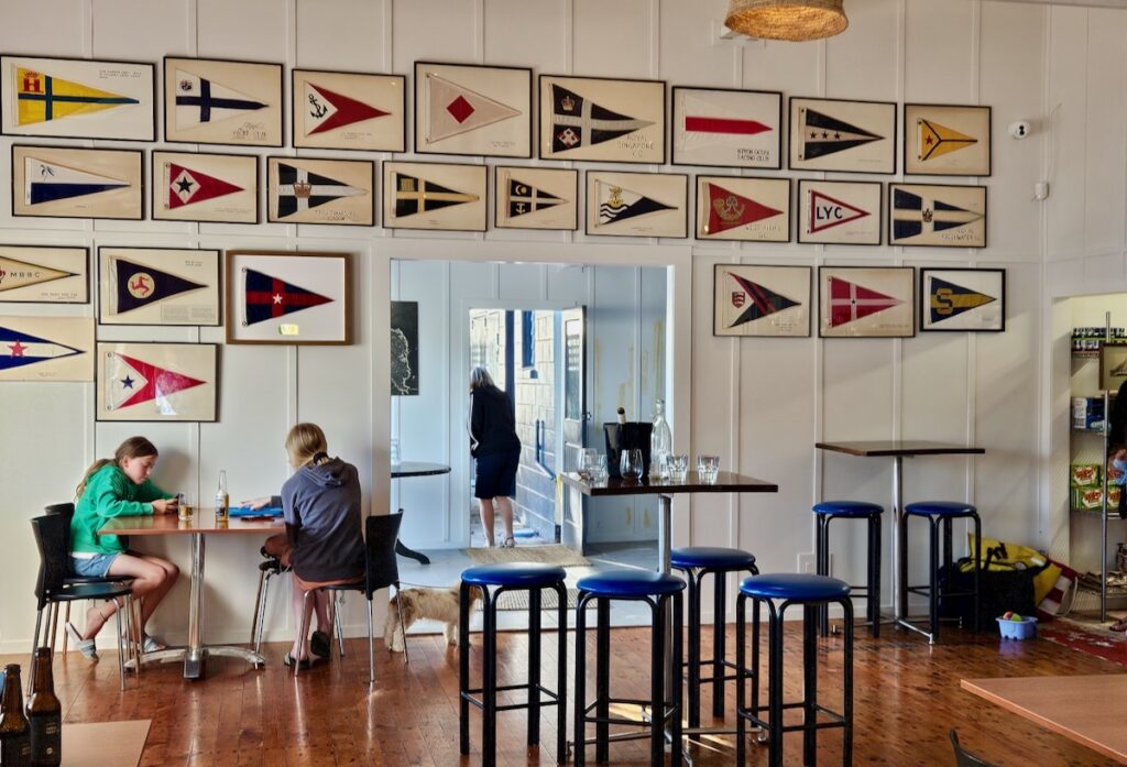 Inside the Kawau Boating Club, sail flags, tables