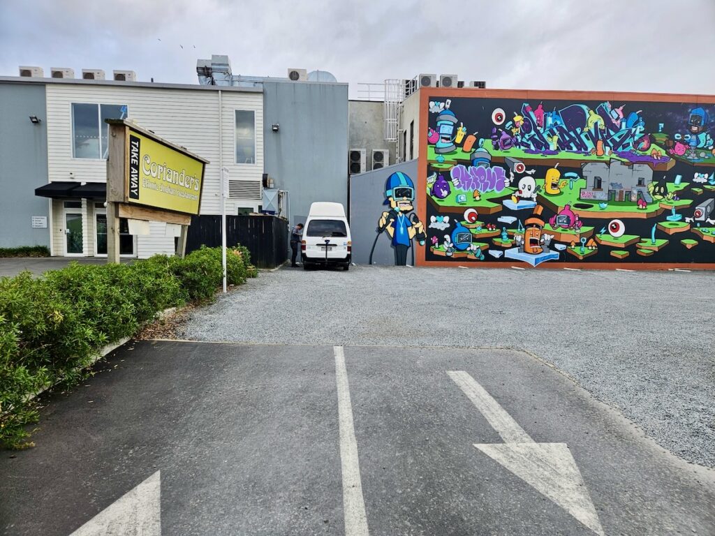 campervan in a parking lot with graffiti mural