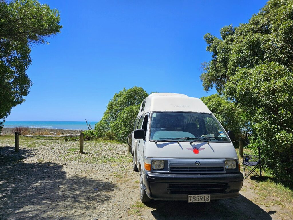 Toyota Hiace campervan parked at beach campsite