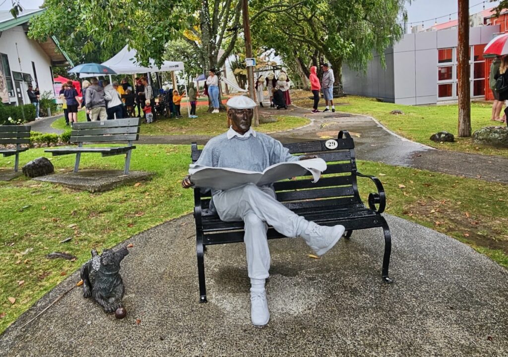 Man and dog sculptures, man on bench