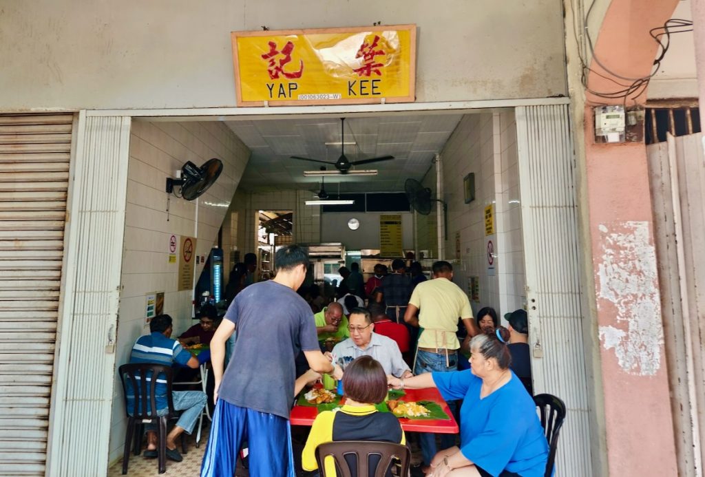 Diners eating Yap Kee's traditional banana leaf chicken rice