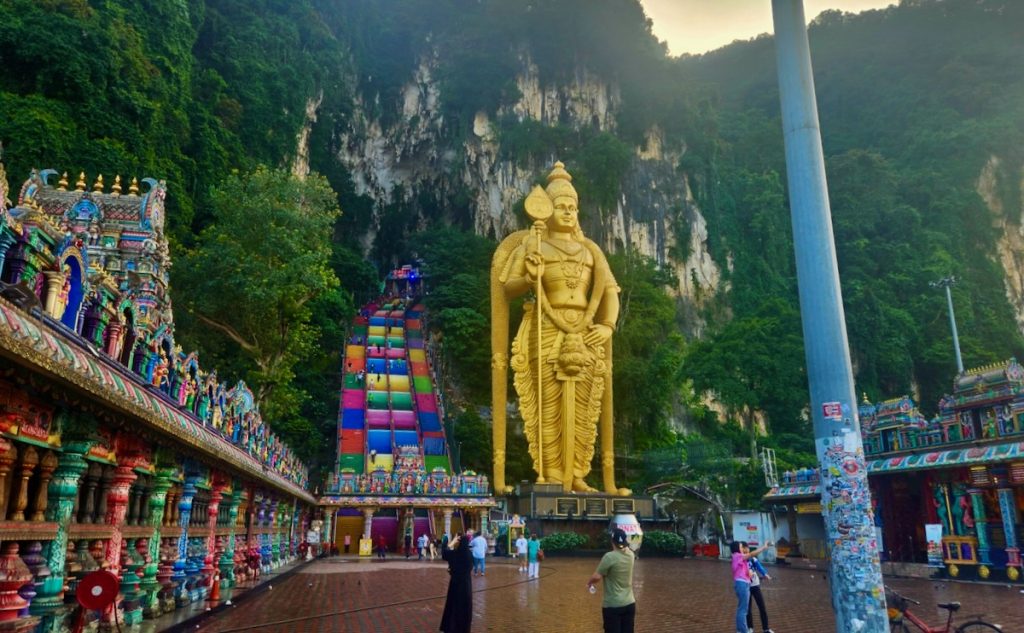 massive gold statue and rainbow steps lead to Batu Caves